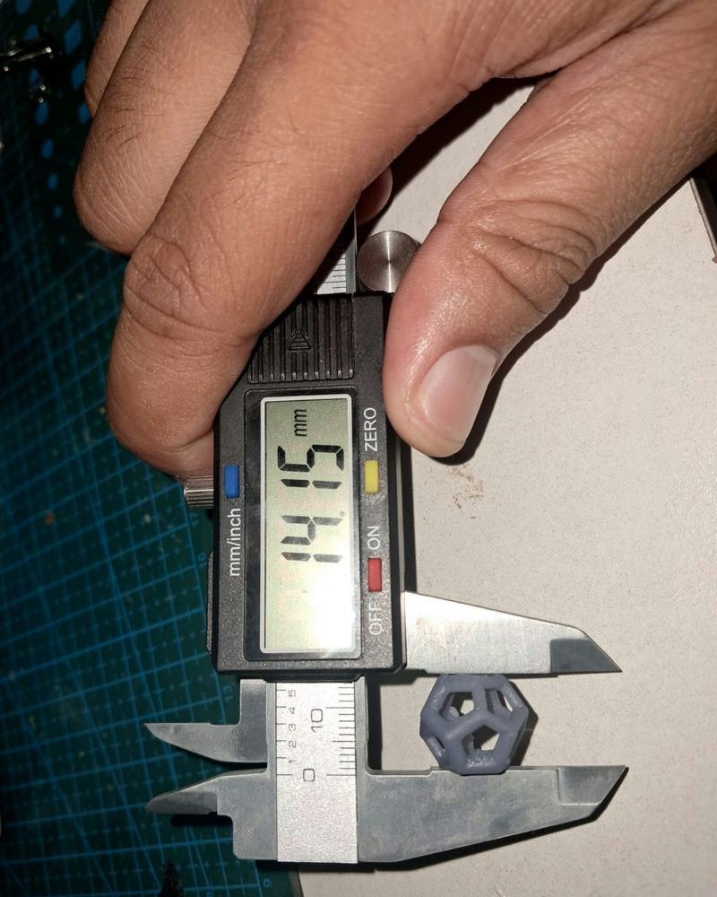 Part dodecahedron hasil cetak resin diukur dengan jangka sorong digital, terbaca 14.15 mm